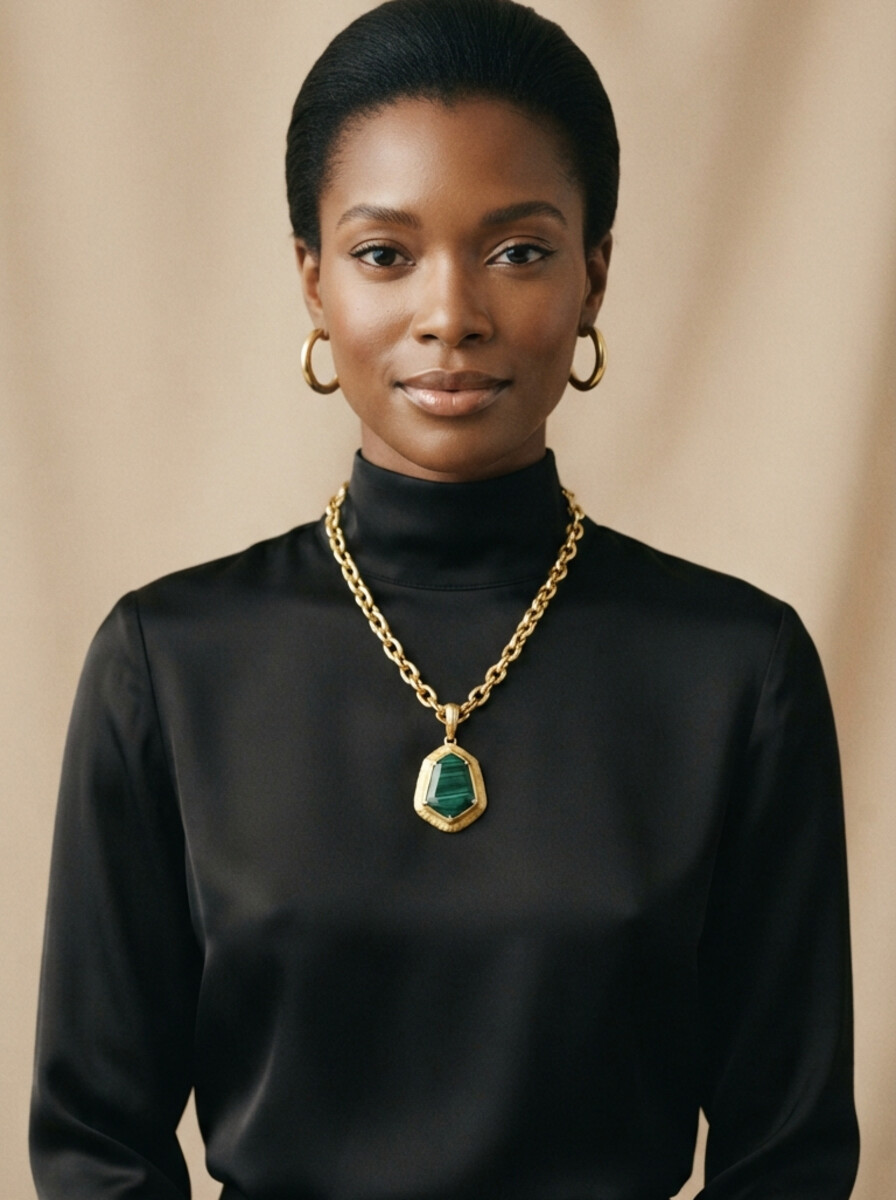 Atelier The Luxury Minerals: modelo con blusa negra de seda luciendo cadena de oro 10K con dije y aretes de aro del catalogo