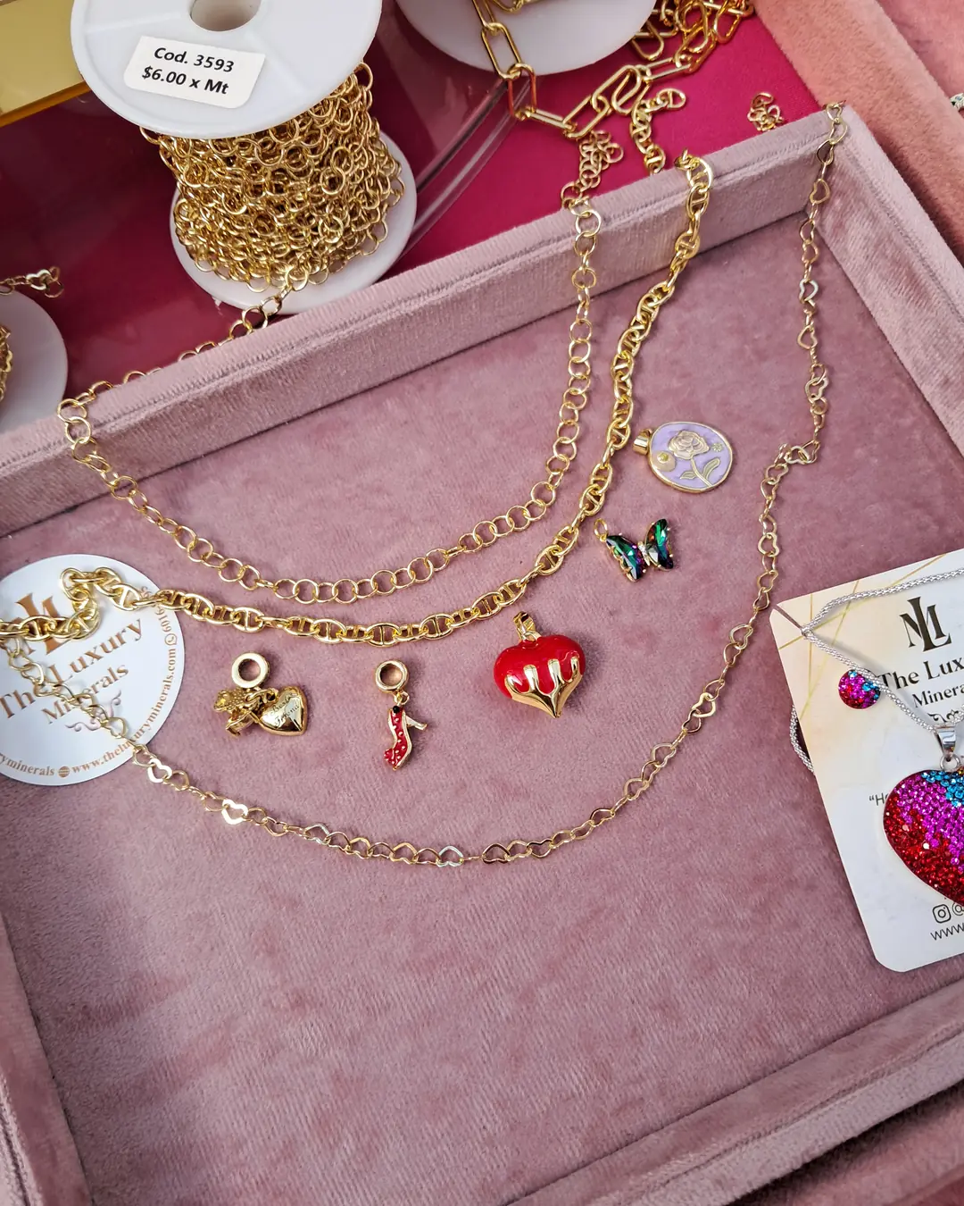 Charm Bar de The Luxury Minerals, foto 4: collar y pulsera de oro con charms exhibidos en soporte rosa