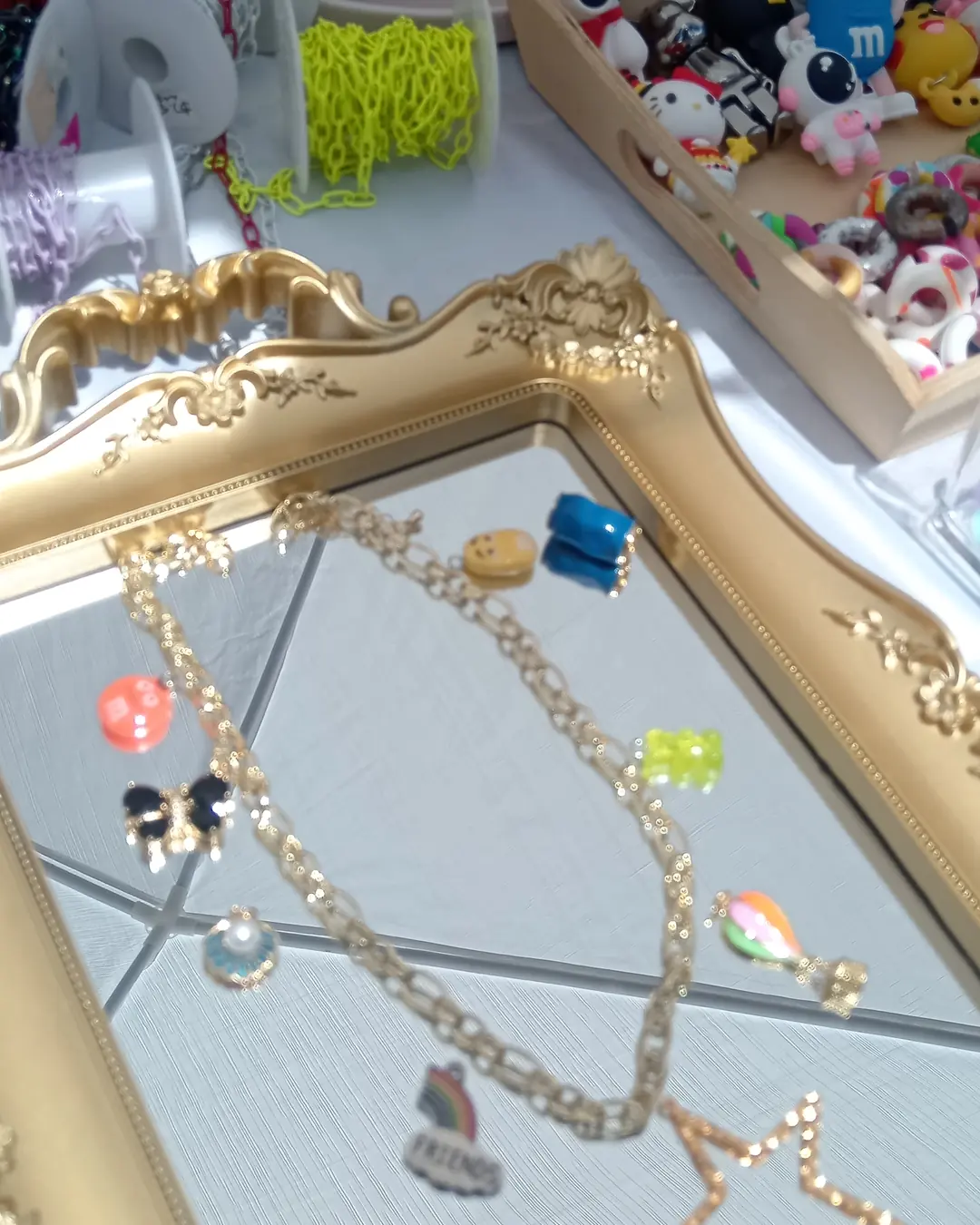 Charm Bar de The Luxury Minerals, foto 9: pulseras de charms colgadas en un espejo con marco dorado